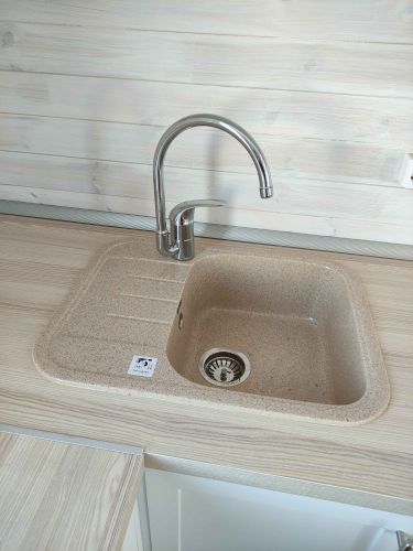 Установлена кухонная столешница из ДСП с интегрированной мойкой и смесителем. Все элементы аккуратно подогнаны и закреплены, обеспечивая функциональность и эстетичный вид.