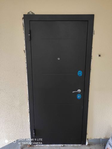 Установлена новая стальная дверь, выполнена герметизация швов, закреплены петли, врезан замок, проведена регулировка конструкции, обеспечена надежная изоляция, завершены отделочные работы.