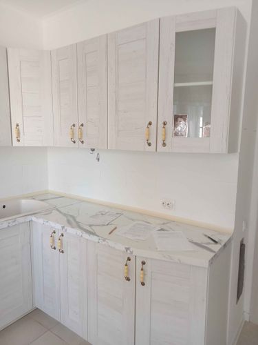 Установлены шкафы, закреплены дверцы, смонтирована столешница, подключена мойка, установлены ручки. Все элементы выровнены и надежно зафиксированы.