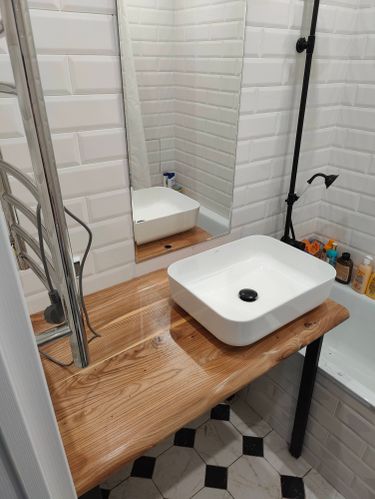 Зеркало аккуратно закреплено на стене в ванной комнате, обеспечивая надежность и эстетичность. Работы выполнены с учетом уровня и симметрии, создавая гармоничное дополнение к интерьеру.