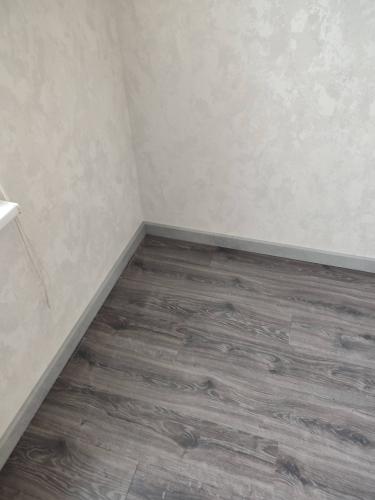 Установлены новые плинтусы вдоль стен, аккуратно закреплены, без зазоров. Завершено оформление стыков, обеспечена ровность и плотное прилегание к поверхности пола и стен.