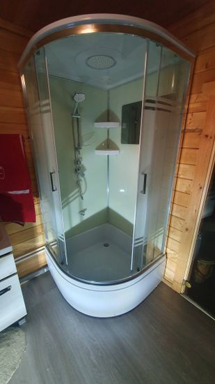 Установлена современная душевая конструкция с гидромассажем, подключены все коммуникации, закреплены стеклянные панели, смонтированы полки и лейка, проверена герметичность соединений.