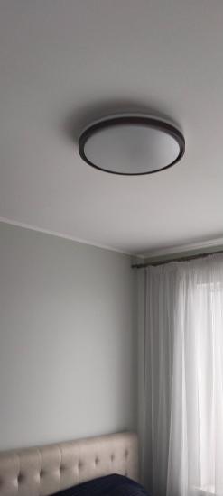 Закреплен круглый светильник на потолке, подключены провода, установлены люминесцентные лампы, проверена работа. Завершено оформление освещения в комнате, обеспечено равномерное свечение.