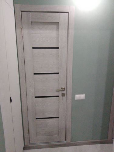 Установлены декоративные элементы вокруг двери, обеспечивая аккуратный и завершённый вид. Элементы плотно прилегают, скрывая зазоры и создавая эстетичный переход между стеной и дверной коробкой.