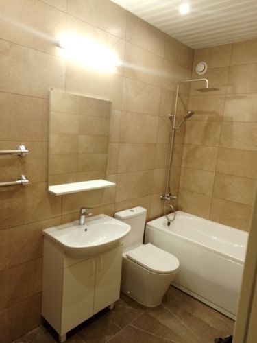 Зеркало аккуратно закреплено на стене ванной комнаты. Установлено над раковиной, обеспечивая удобство использования. Работа выполнена качественно, с учетом всех необходимых мер безопасности.