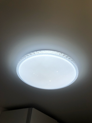 Установлен круглый потолочный светильник с декоративной окантовкой. Подключение выполнено аккуратно, обеспечено равномерное освещение. Завершено безупречно, светильник надежно закреплен.