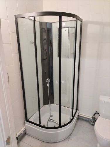 Установлена современная душевая конструкция с низким основанием. Смонтированы стеклянные панели, закреплены дверцы, подключены водопроводные коммуникации, герметизированы швы.