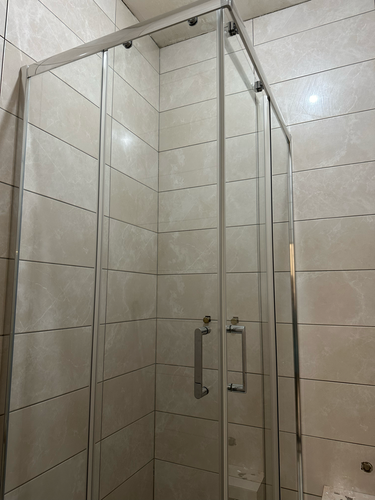 Установлены стеклянные панели, закреплены металлические профили, смонтирована дверца с ручкой, обеспечена герметичность соединений, проверена устойчивость конструкции, завершена отделка.