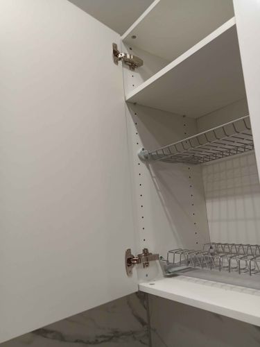 Обновлены дверцы шкафа, установлены петли, проведена точная подгонка элементов. Внутри добавлены металлические полки для удобства хранения. Работа завершена аккуратно и качественно.