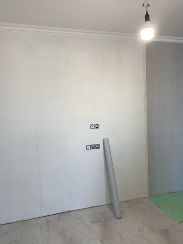 На стену нанесен стеклохолст, поверхность выровнена, подготовлена к дальнейшей отделке. Углы и стыки аккуратно обработаны, материал плотно прилегает, создавая гладкую основу.