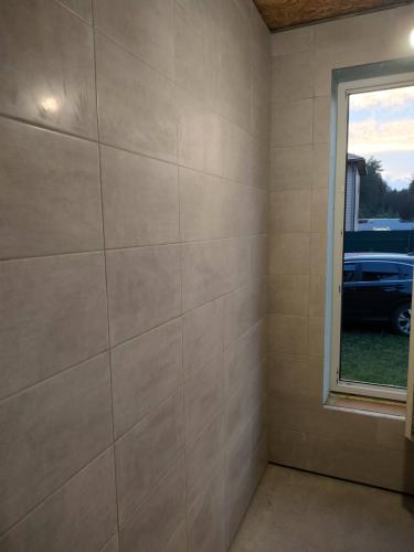 Стены облицованы керамической плиткой светлого оттенка, швы аккуратно затерты, поверхность ровная, без дефектов. Углы и стыки обработаны, создавая завершенный вид помещения.