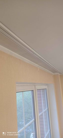 Закреплен профиль для штор на стене над окном. Проведены замеры, просверлены отверстия, установлены крепления, зафиксирован карниз. Работа завершена аккуратно и надежно.