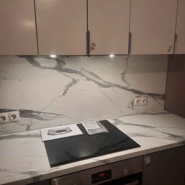 Установлены шкафы, закреплены фасады, смонтирована столешница, подключена варочная панель, выполнена сборка и фиксация фартука, установлены розетки, завершена отделка.