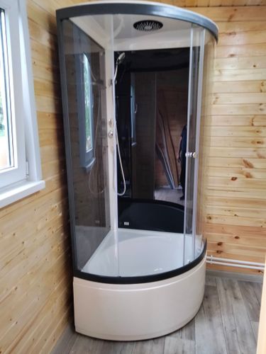 Установлена угловая душевая конструкция с низким основанием, подключены водопроводные коммуникации, закреплены стеклянные панели, герметизированы стыки, проверена функциональность оборудования.