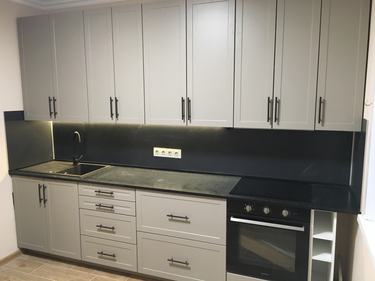 Установлена гладкая поверхность из искусственного камня, идеально подогнанная к кухонным шкафам и оборудованию, с интегрированной мойкой и вырезами для техники, обеспечивая современный вид.