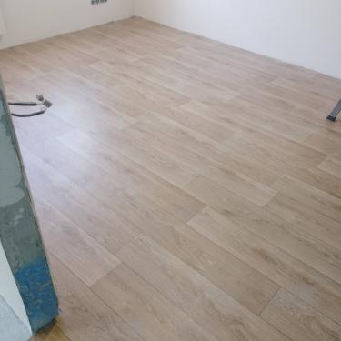 Покрытие уложено на подготовленное основание, ровно и аккуратно, без зазоров. Пол выглядит гладким и эстетичным, создавая уютную атмосферу в помещении.