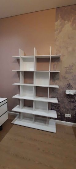 Собрана конструкция из полок, закреплена на полу, выровнена по уровню. Все элементы соединены, обеспечена устойчивость и надежность. Установлена в комнате, готова к использованию.