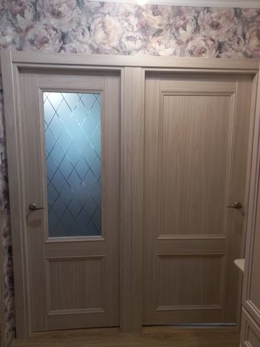 Установлена новая дверь с декоративным стеклом, выполнена подгонка по размеру проема, закреплены петли, врезана ручка, отрегулировано полотно для плавного открывания, оформлен наличник.