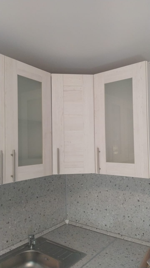 Установлены шкафы, смонтирована столешница из искусственного камня, подключена мойка. Завершена сборка и установка кухонного гарнитура с учётом всех деталей и особенностей помещения.