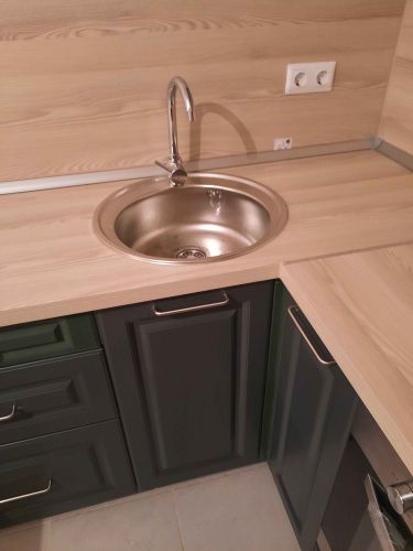 Установлены шкафы, закреплены фасады, смонтирована столешница, врезана мойка, подключен смеситель, установлены розетки, прикреплены ручки. Завершена сборка и установка всех элементов.