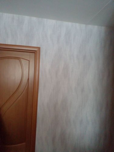 На стену аккуратно наклеены фотообои с абстрактным узором, создающим стильный интерьер. Полотно ровно прилегает, без видимых швов и пузырей, обеспечивая гармоничный вид помещения.