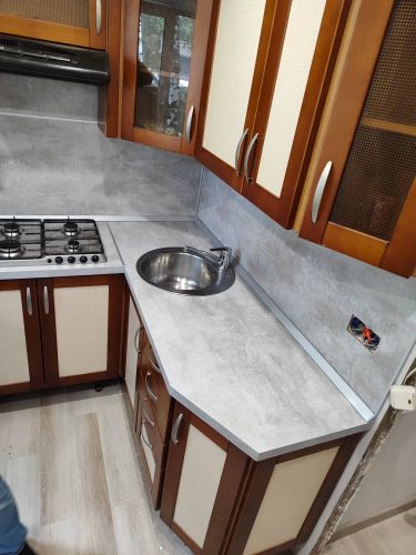 Установлена новая столешница из ДСП, выполнены вырезы под мойку и плиту, закреплены все элементы, обеспечена герметизация швов, проведена финальная проверка качества монтажа.