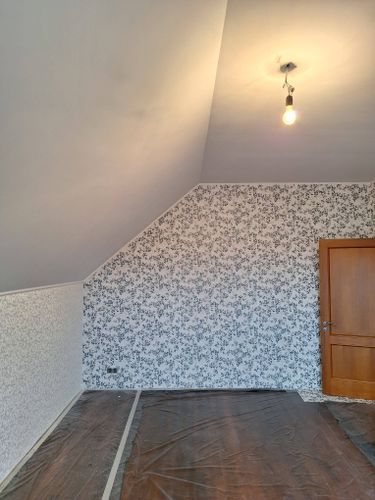 На стенах аккуратно наклеен стеклохолст с узором, создавая ровную и эстетичную поверхность. Пол защищен пленкой, обеспечивая чистоту и порядок в помещении.