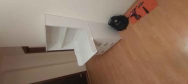 Собран белый комод с полками и выдвижными ящиками. Установлены ручки, закреплены все детали. Инструменты использованы для точной сборки, обеспечена устойчивость конструкции.