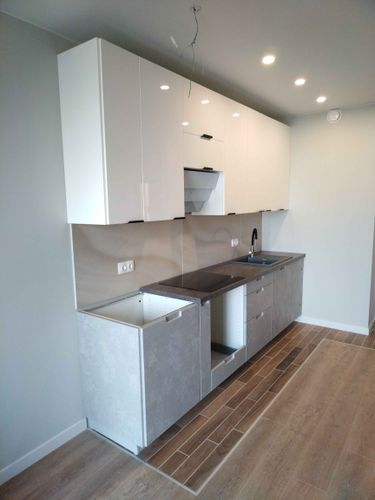 Установлены шкафы, закреплены фасады, смонтирована столешница, подключена мойка, выполнен монтаж фартука, установлены розетки, проведено освещение, уложен пол.