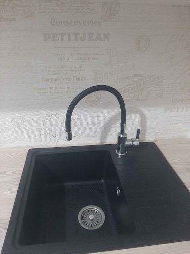 Установлена кухонная мебель, смонтирована столешница, врезана раковина, подключен смеситель. Завершены работы по сборке и установке всех элементов, включая фурнитуру и сантехнику.