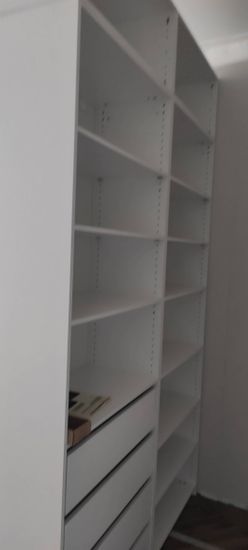 Установлена белая стеллажная конструкция с несколькими уровнями. Все элементы надежно закреплены, обеспечивая устойчивость и функциональность для хранения предметов в интерьере.