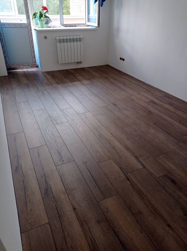 Покрытие пола выполнено: уложены панели, подогнаны стыки, обеспечена ровность, соблюдены зазоры, завершена отделка, создана гладкая поверхность, обеспечен эстетичный вид.