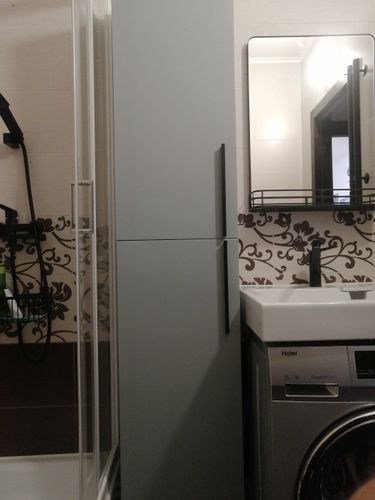 Завершена установка зеркала в ванной комнате. Оно аккуратно закреплено на стене над раковиной, обеспечивая удобство использования и эстетичный вид.