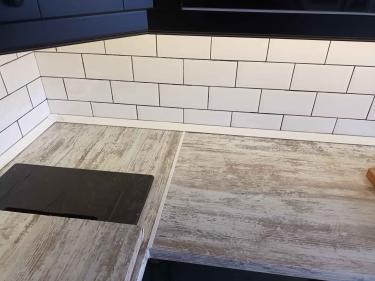 Обновлена поверхность на кухне, установлена новая панель с текстурой дерева, вырезано отверстие для плиты, обеспечена аккуратная подгонка и надежное крепление.