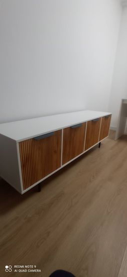 Собрана новая мебель: установлены дверцы, прикреплены ручки, закреплены ножки. Все элементы соединены, конструкция устойчива, готова к использованию.