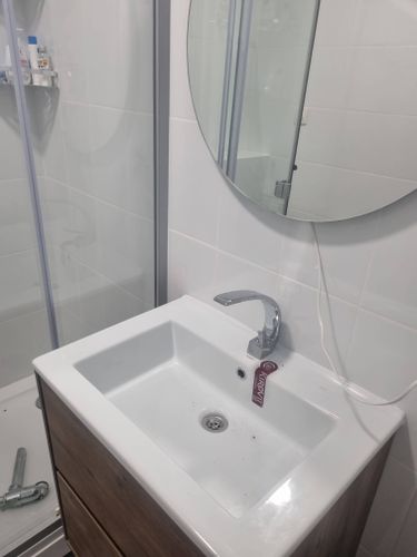 Изображен установленный новый смеситель на раковине в ванной комнате. Старый кран демонтирован, проведена замена, проверена герметичность соединений, обеспечена функциональность.