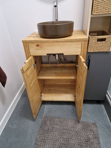 Собрана деревянная конструкция с дверцами и полкой, установлена раковина. Подключены трубы, обеспечена устойчивость. Завершена установка в ванной комнате.