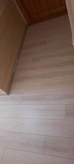 Уложено новое покрытие, ровные панели светлого оттенка, без зазоров, аккуратно состыкованы, создают гладкую поверхность. Завершена отделка, обеспечивающая эстетичный вид помещения.