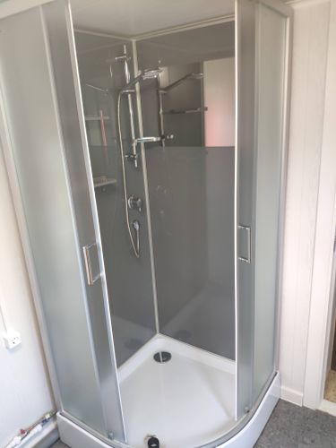 Установлена новая душевая кабина: смонтированы стенки, поддон, дверцы, подключены смеситель и лейка, проведены коммуникации, герметизация швов. Завершено оформление пространства.