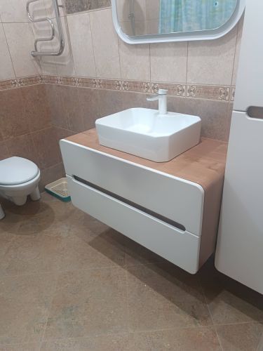 Установлена раковина на деревянную столешницу, подключены водопровод и слив, закреплены все элементы. Проверена герметичность соединений, обеспечена функциональность и эстетичность.