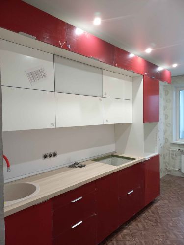 На изображении показаны установленные кухонные фасады, выполненные в красно-белой гамме. Все элементы аккуратно подогнаны и закреплены, обеспечивая функциональность и эстетичность интерьера.