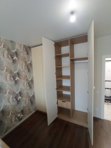 Собран вместительный шкаф с полками и штангой для одежды. Установлены дверцы, обеспечивающие удобный доступ. Конструкция надежно закреплена, гармонично вписывается в интерьер.