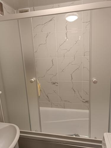 Установлена акриловая ванна, смонтированы стеклянные раздвижные двери, герметично заделаны швы, подключена система слива, проверена функциональность, выполнена облицовка стен керамической плиткой.