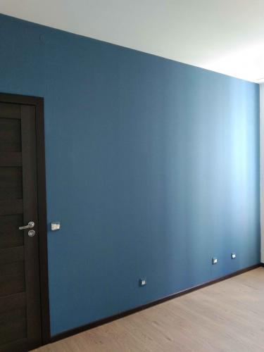 Стены покрыты равномерным слоем синей краски, создавая гладкую и однородную поверхность. Углы и края обработаны аккуратно, без потеков и неровностей, обеспечивая чистый и свежий вид.