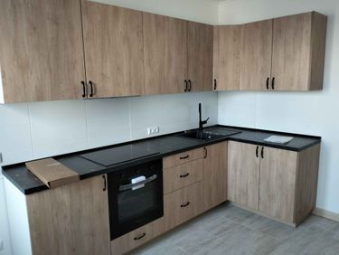 Установлены шкафы, закреплены фасады, смонтирована столешница, подключена мойка, встроена варочная панель и духовой шкаф, установлены ручки, проведены завершающие работы по сборке и настройке.