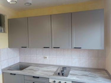 Установлены шкафы, смонтирована столешница, врезана мойка, подключена варочная панель. Завершена облицовка фартука плиткой. Все элементы аккуратно выровнены и закреплены.