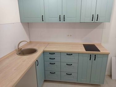 Установлены шкафы, закреплены фасады, смонтирована столешница, врезана мойка, подключен смеситель, установлена варочная панель, закреплены ручки, выполнена отделка стен.