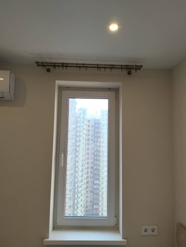 Установлен карниз для штор над окном, закреплён потолочный светильник, смонтирован кондиционер на стене, добавлены двойные розетки.