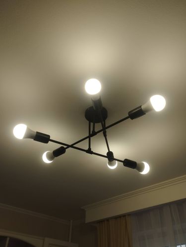 Установлено новое осветительное устройство на потолке, подключены провода, проверена работа ламп, закреплена конструкция. Все элементы надежно зафиксированы, обеспечено равномерное освещение.