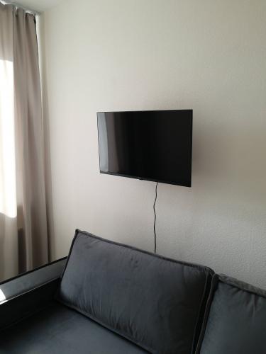 Телевизор аккуратно закреплен на стене, провода упорядочены. Устройство установлено на оптимальной высоте для комфортного просмотра, обеспечивая эстетичный вид интерьера.